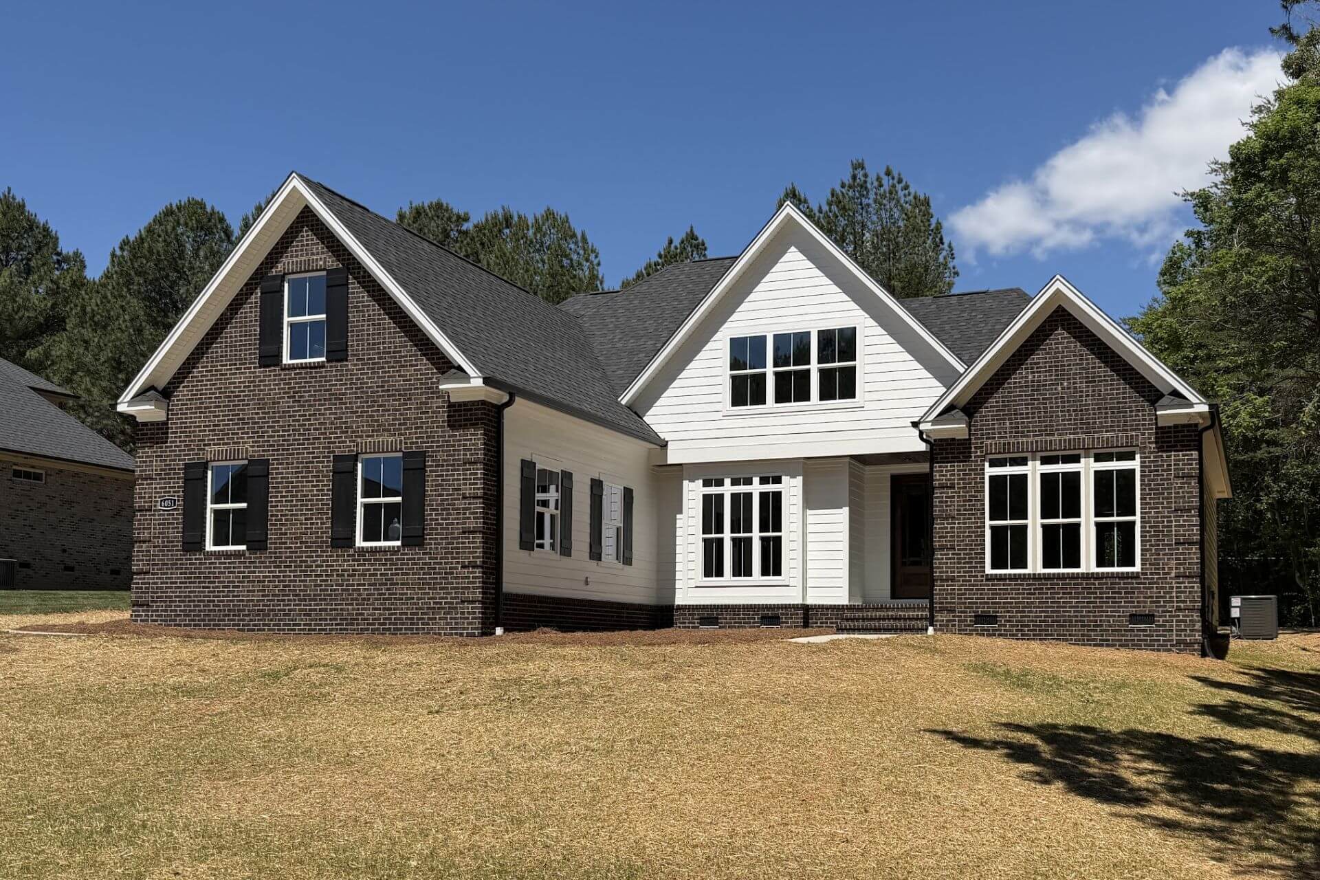 a completed mike palmer home with brick and white siding