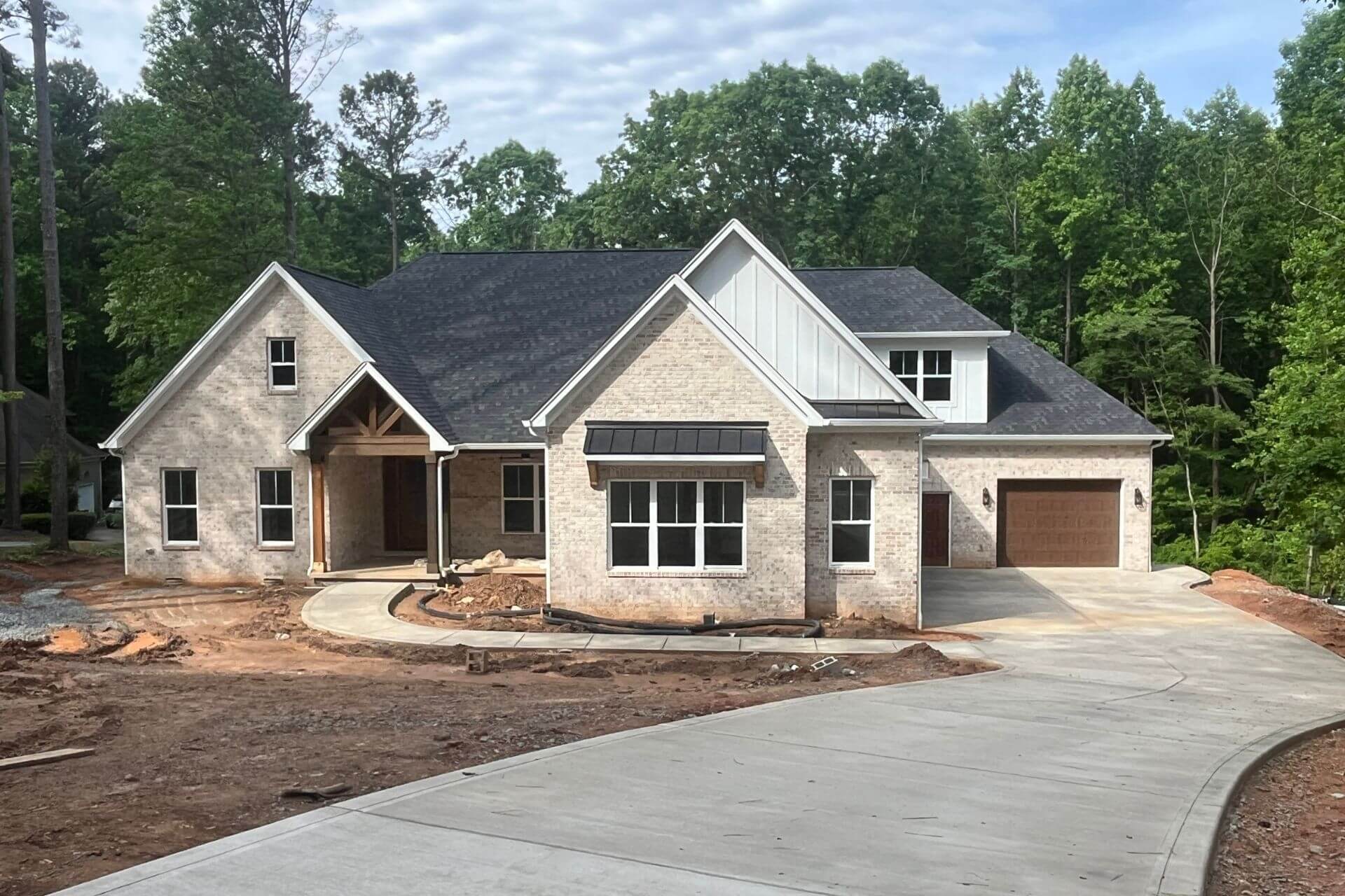 Finished mike palmer home with white brick and siding.